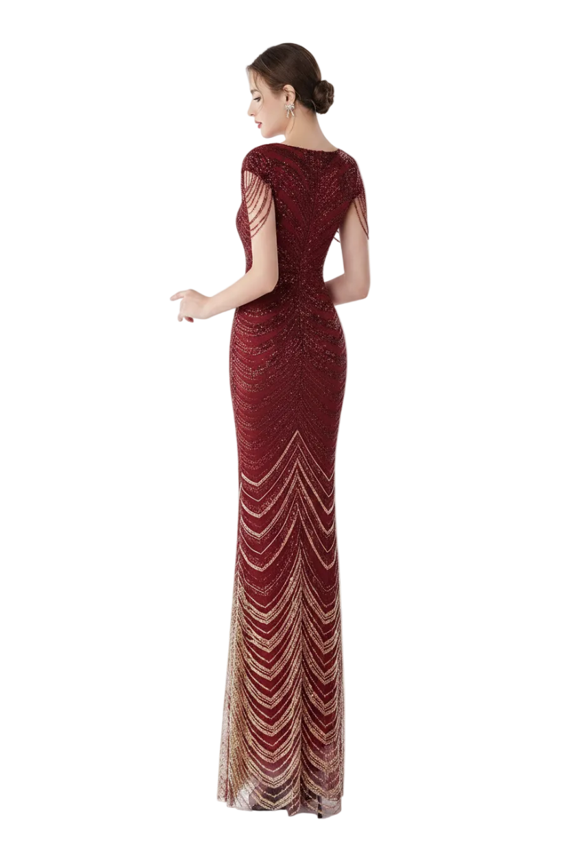 Woman in a red evening gown standing in front of a mirror.