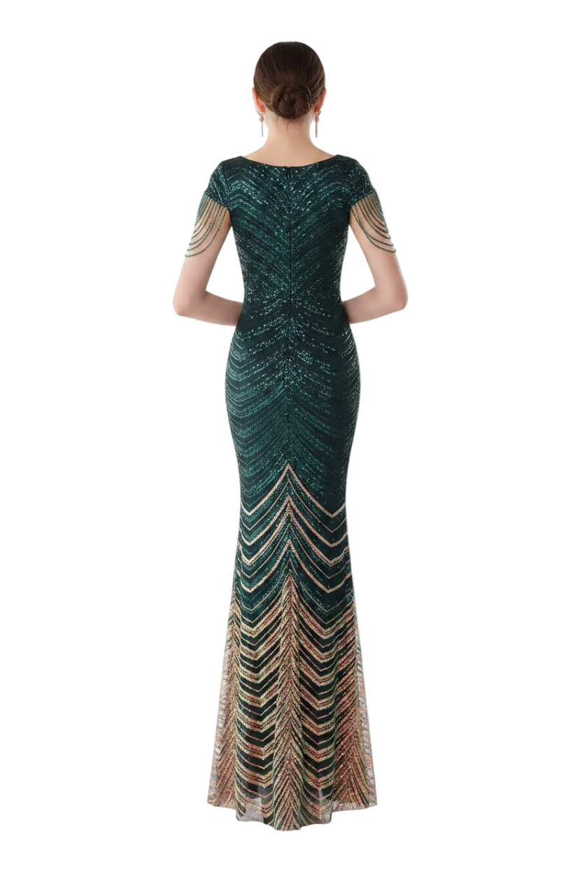 Woman in a long, dark green dress with multicolor pattern standing in front of a mirror.