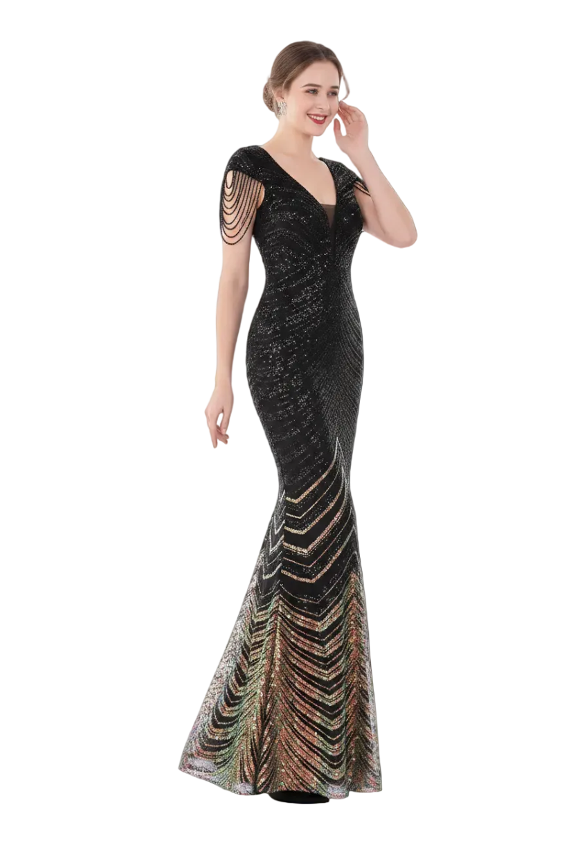 Woman in a black evening gown with colorful details standing in front of a mirror.