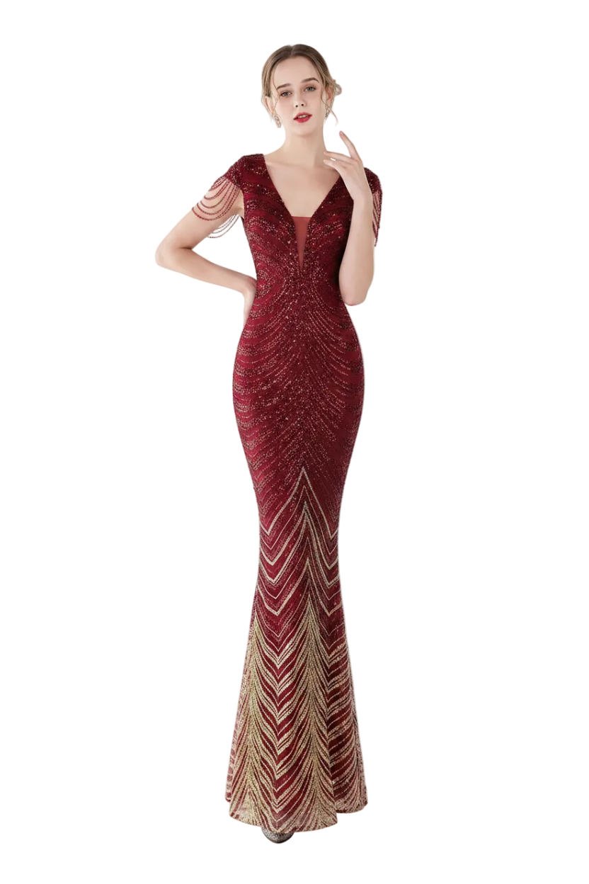 Woman in a red beaded evening gown standing in front of a mirror.