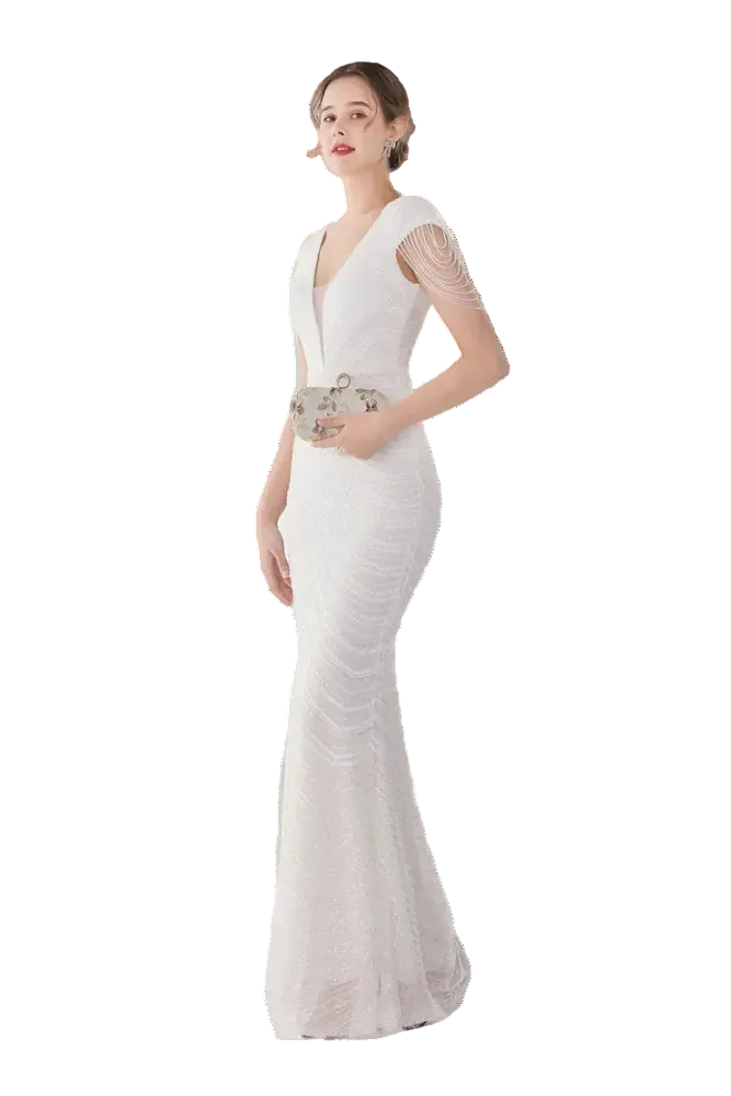 Woman in a white evening gown standing in a room with a mirror and white curtains.