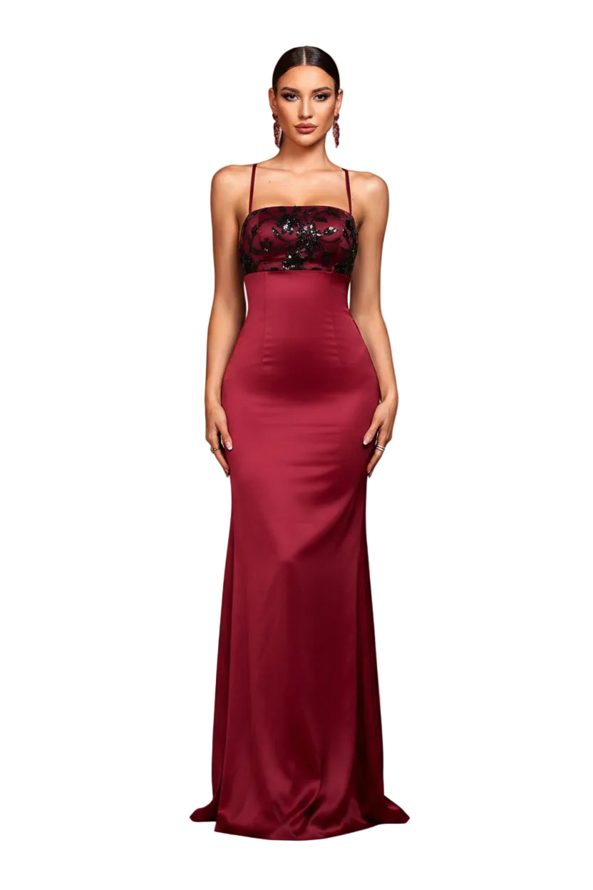 Woman in a burgundy evening gown with black lace top in an elegant interior setting