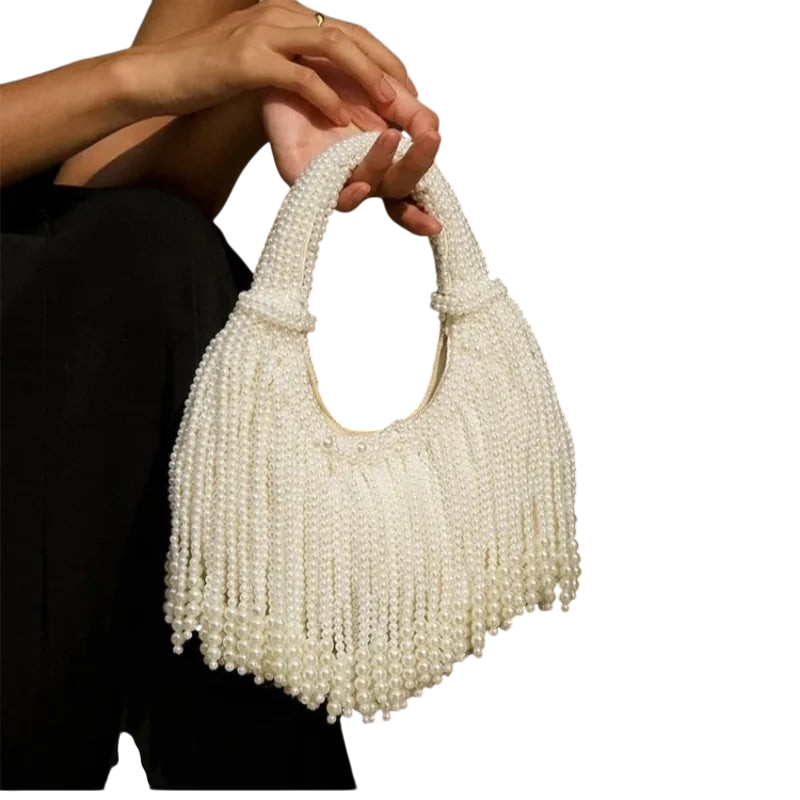 JASE HEART GLOBAL white pearl beaded handbag with fringe detail held by a person in a black outfit