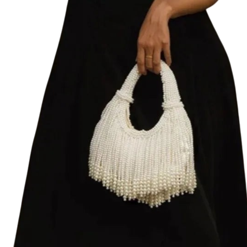 JASE HEART GLOBAL white pearl beaded handbag with fringe detail held by a woman in a black dress