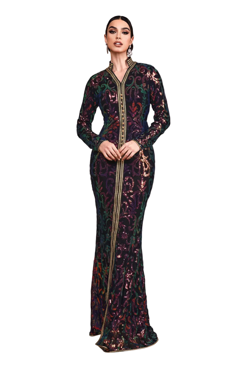 Woman in a long, dark floral dress standing in a desert landscape with sand dunes.