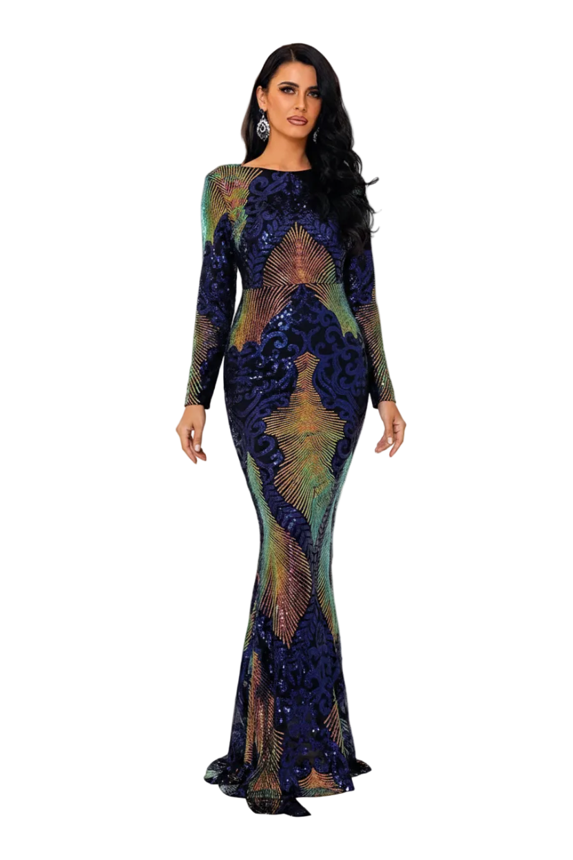 A woman stands in a bright white hallway wearing a floor-length, long-sleeve mermaid gown with an intricate sequined and embroidered pattern in navy blue, gold, and green. She holds a glass of red wine.