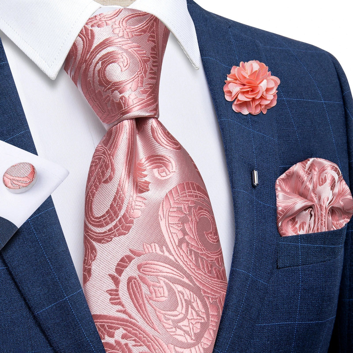 JASE HEART GLOBAL pink paisley silk necktie set with matching pocket square, lapel flower, and cufflinks on blue suit