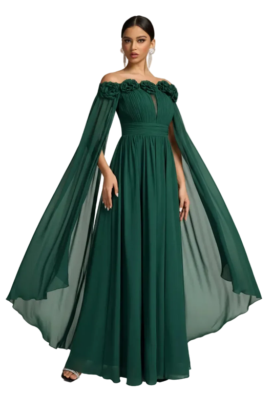 A woman modeling a floor-length off-the-shoulder gown in deep emerald green. The dress features a structured bodice with floral applique at the shoulders, a fitted waist, and a flowing sheer cape-like overlay that extends from the shoulders.