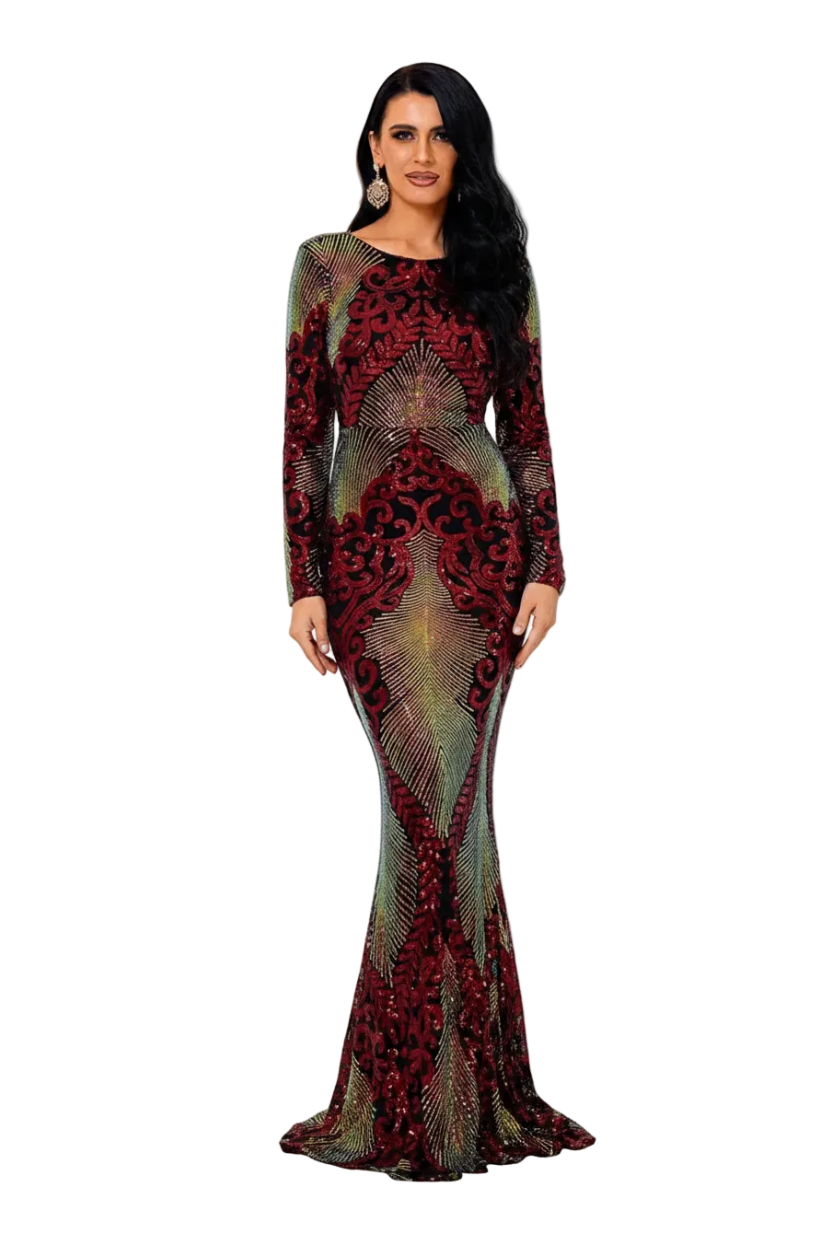 A woman models a floor-length, long-sleeve mermaid gown with a red and green abstract pattern, standing in a bright white hallway.