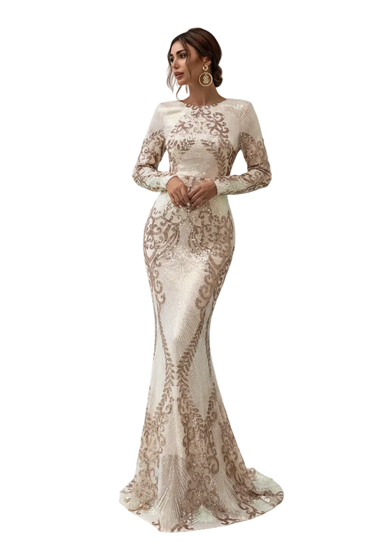 A woman models a long-sleeve, high-neck mermaid gown covered in shimmering sequins and floral embroidery. The dress features a fitted bodice and a flared skirt with a slight train, set against a background of white pillars and gray stone flooring.