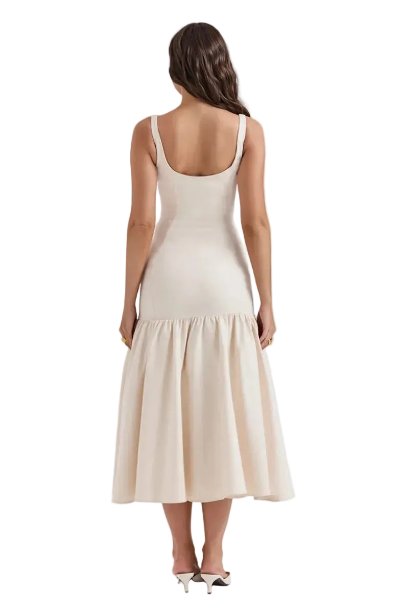 A woman shown from the back wearing a sleeveless, scoop-neck midi dress in a light cream or off-white color. The dress features a fitted bodice and a flared, tiered skirt.