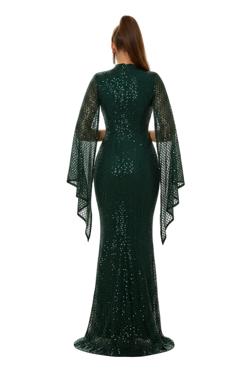 Woman in a green sequin dress with cape standing in a doorway.
