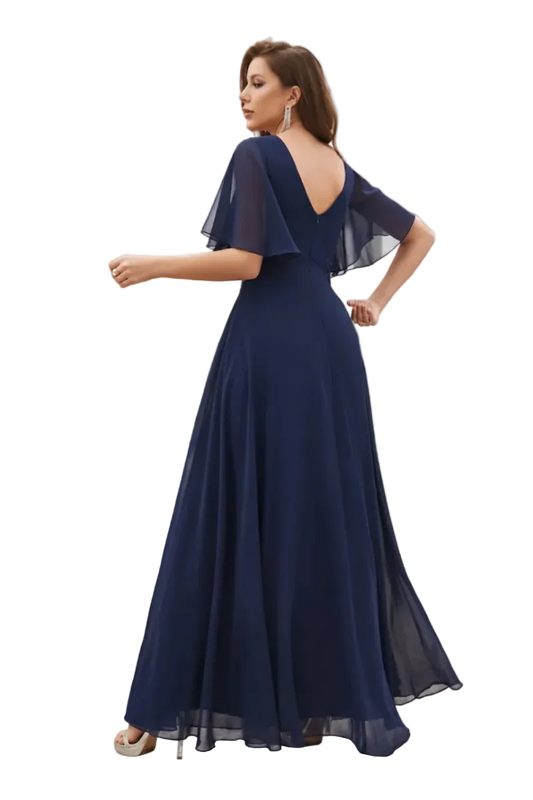 Woman in a navy blue evening gown standing outdoors with columns and greenery in the background