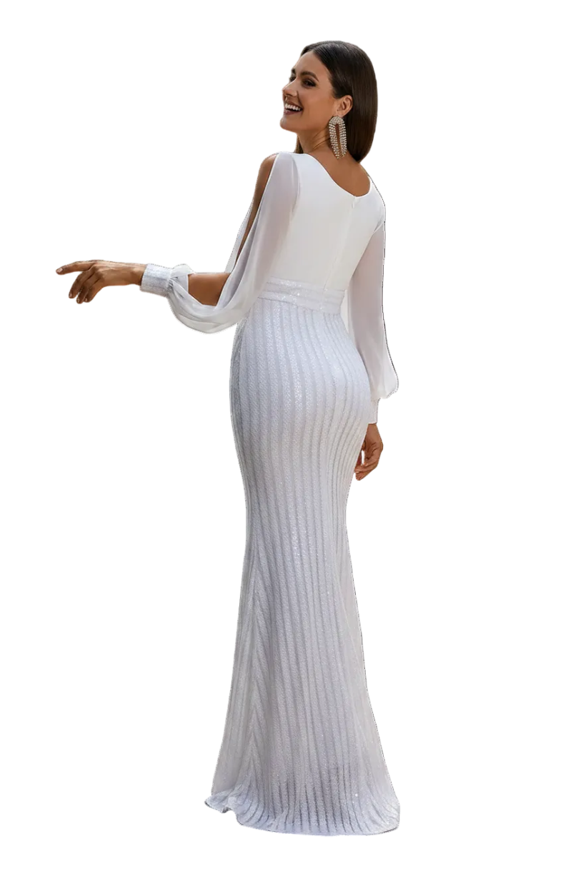 A woman wearing a white long-sleeve mermaid gown stands on a tiled balcony, shown from the back. The dress has a fitted bodice, sheer long sleeves, and a textured, ribbed skirt that flares out at the bottom.