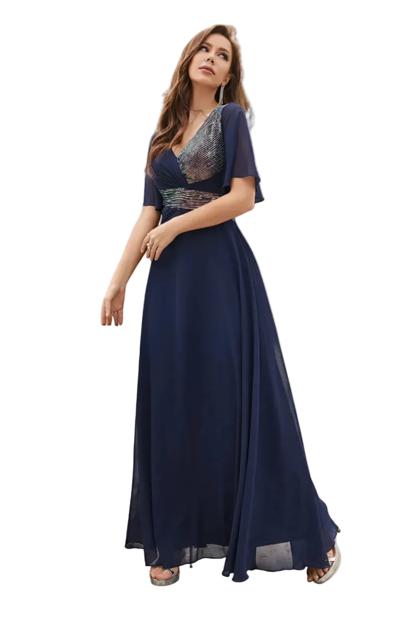 Woman in a long navy dress standing outdoors with palm trees in the background