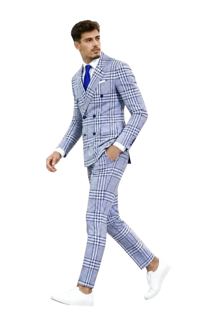 A man modeling a light blue and white plaid double-breasted suit with a white shirt, blue tie, and white shoes, walking against a textured white background. A black 'UA' logo is visible in the top-left corner.