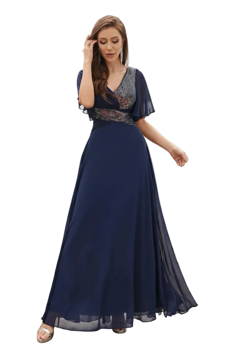 Woman in a navy blue evening gown standing outdoors with palm trees and a pool in the background.